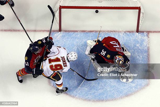 David Jones of the Calgary Flames scores against Goaltender Al Montoya of the Florida Panthers and teammate Brian Campbell at the BB&T Center on...