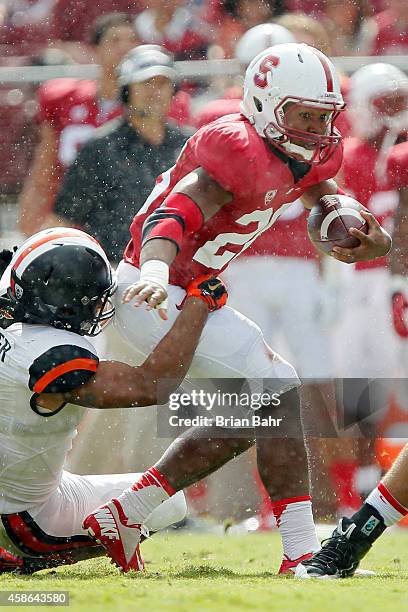 Running back Barry Sanders of the Stanford Cardinal carries the ball for five yards after a catch as he is brought down by linebacker D.J. Alexander...