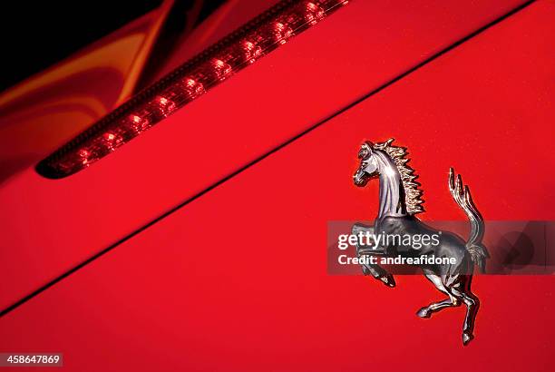 ferrari macro di cavallo logo su sfondo rosso - ferrari foto e immagini stock