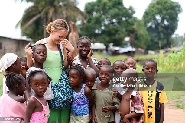 young missionary with african kids - missionary stock pictures, royalty-free photos & images