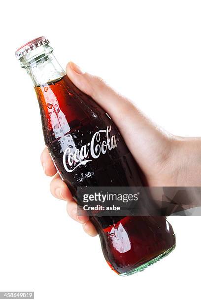 hand holding coca-cola bottle - cola stock-fotos und bilder