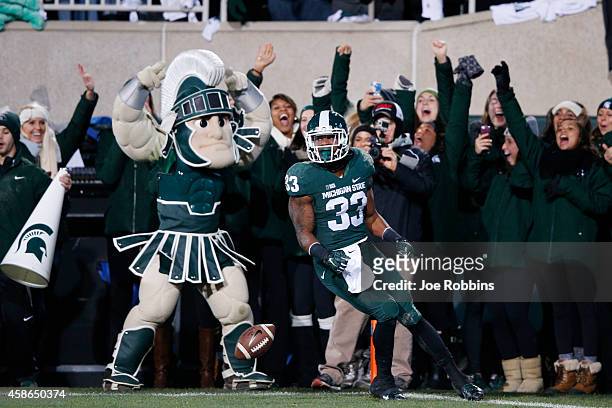 Jeremy Langford of the Michigan State Spartans celebrates after running for a 33-yard touchdown in the first quarter of the game against the Ohio...