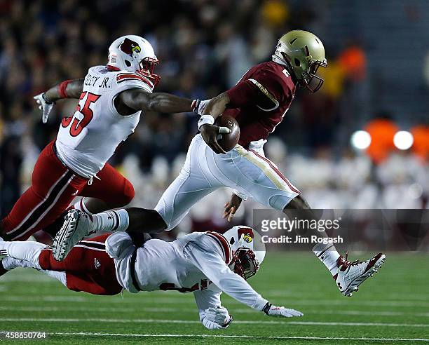 Keith Kelsey and Charles Gaines of the Louisville Cardinal chase Tyler Murphy of the Boston College Eagles in the second quarter at Alumni Stadium on...