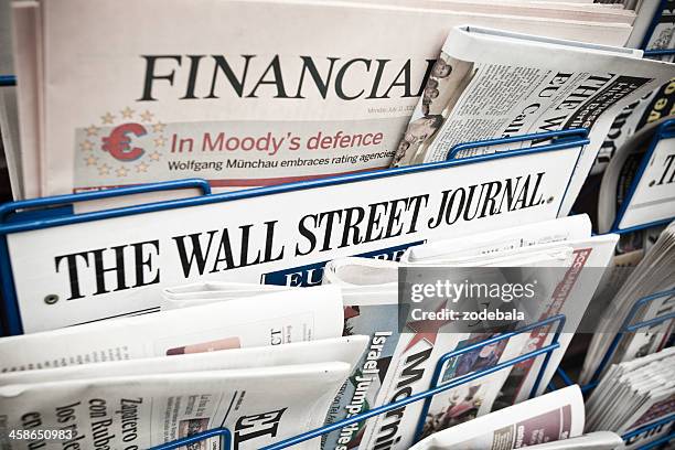 financial newspapers on a newsstand - wall street journal newspaper stock pictures, royalty-free photos & images