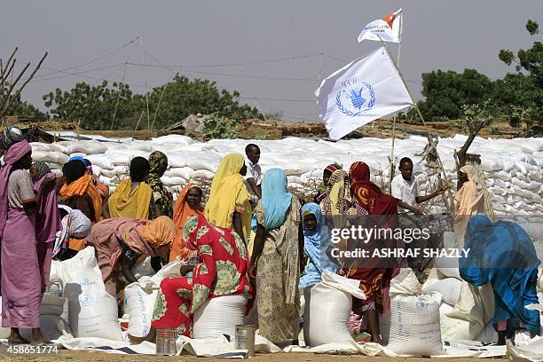 Sudanese displaced women collect humanitarian aid supplies provided by the UN's World Food Program, on November 6 in the Kalma camp for internally...