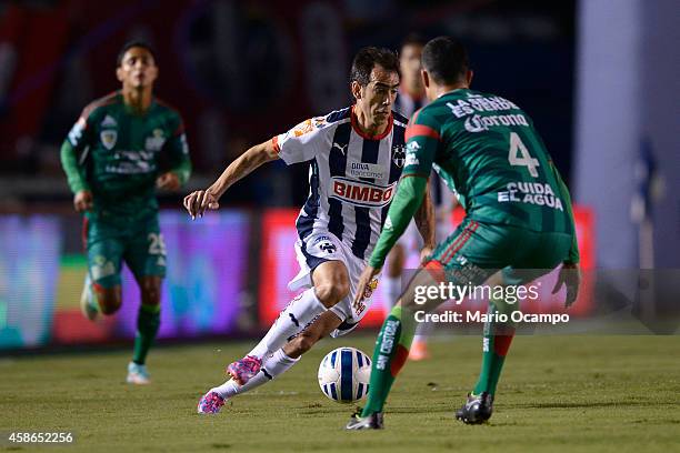 Cesar 'Chelito' Delgado of Monterrey drives the ball as Edgar Dueñas of Chiapas tries to stop him during a match between Monterrey and Chiapas as...