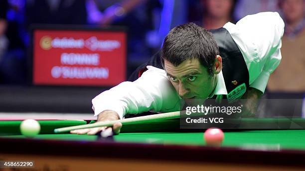 Ronnie O'Sullivan of England plays a shot against Ding Junhui of China on day five of the 2014 Dafabet Champion of Champions at The Ricoh Arena on...