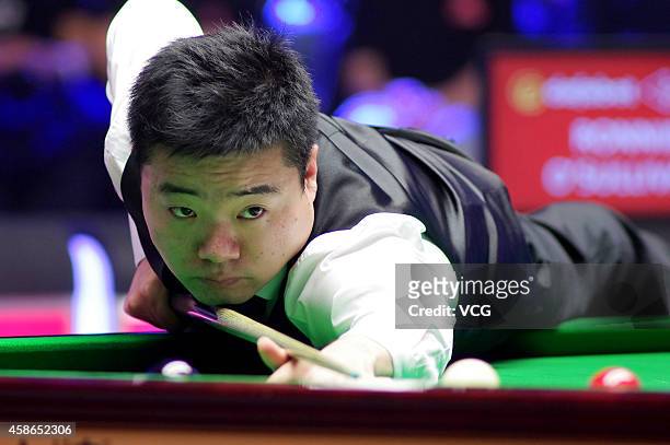 Ding Junhui of China plays a shot against Ronnie O'Sullivan of England on day five of the 2014 Dafabet Champion of Champions at The Ricoh Arena on...