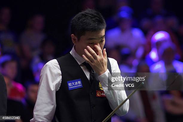 Ding Junhui of China reacts against Ronnie O'Sullivan of England on day five of the 2014 Dafabet Champion of Champions at The Ricoh Arena on November...