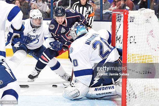 Cam Atkinson of the Columbus Blue Jackets drives to the net and puts a shot on goaltender Evgeni Nabokov of the Tampa Bay Lightning as Radko Gudas of...