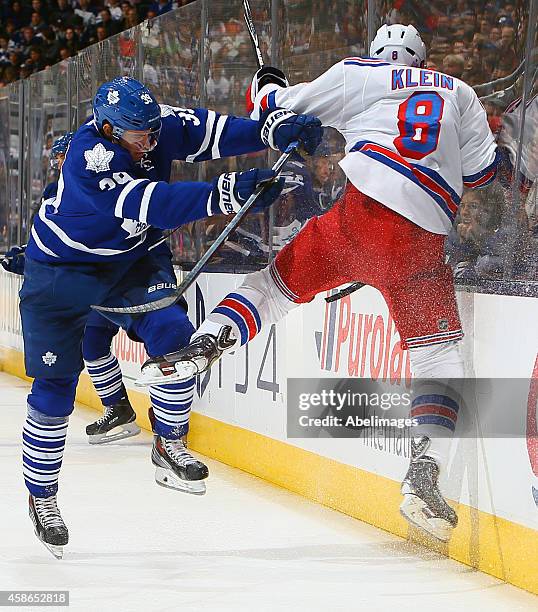 Matt Frattin of the Toronto Maple Leafs runs into Kevin Klein of the New York Rangers during NHL action at the Air Canada Centre November 8, 2014 in...