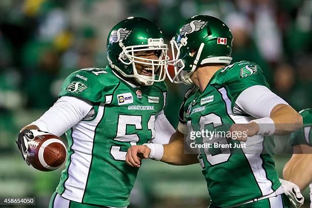 Tristan Black and Brett Swain of the Saskatchewan Roughriders celebrate the recovery of the ball after the Edmonton Eskimos muffed a punt in a game...