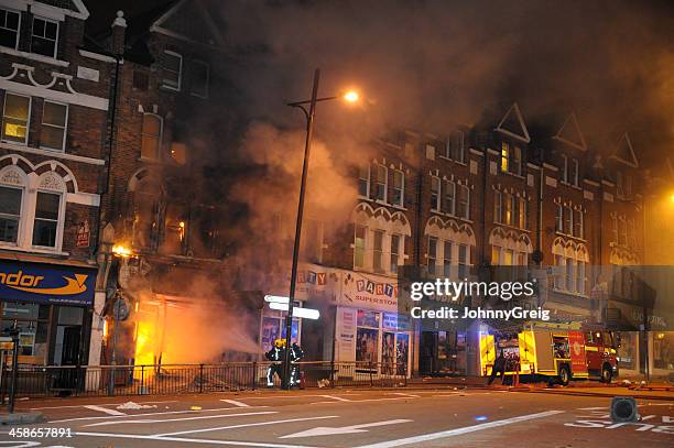 firefighters douse fire after london riots - riot stock pictures, royalty-free photos & images