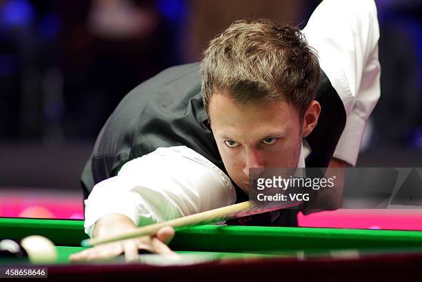 Judd Trump of England plays a shot against Neil Robertson of Australia on day five of the 2014 Dafabet Champion of Champions at The Ricoh Arena on...