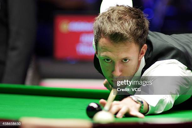 Judd Trump of England plays a shot against Neil Robertson of Australia on day five of the 2014 Dafabet Champion of Champions at The Ricoh Arena on...