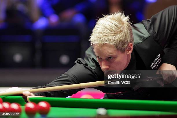 Neil Robertson of Australia plays a shot against Judd Trump of England on day five of the 2014 Dafabet Champion of Champions at The Ricoh Arena on...