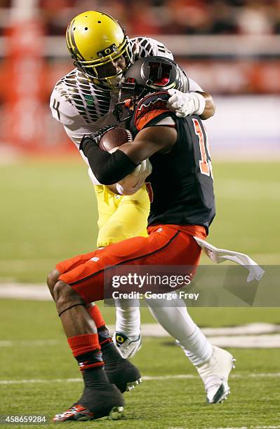 Wide receiver Dominique Hatfield of the Utah Utes is stopped short of a first down on a fourth down by defensive back Erick Dargan of the Oregon...