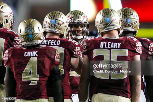 Quarterback Jameis Winston of the Florida State Seminoles talks with his teammates in the huddle during the game against the Virginia Cavaliers at...