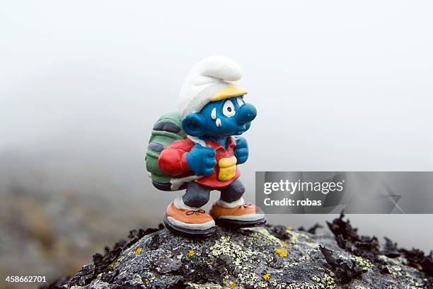 smurf puppet with backpack walking outdoors - de smurfen stockfoto's en -beelden