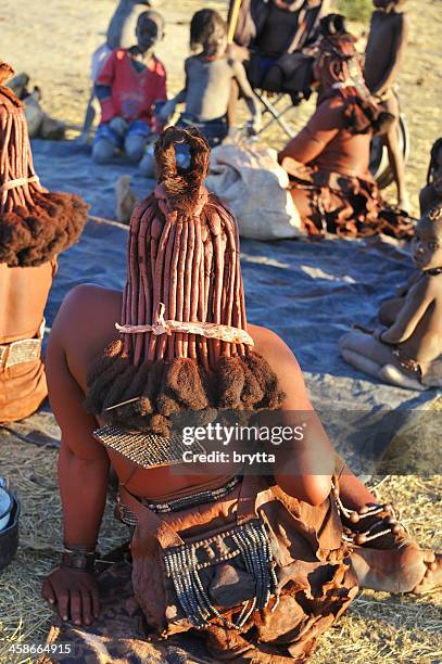 himba family sitting together in village near opuwo,namibia - himba stockfoto's en -beelden