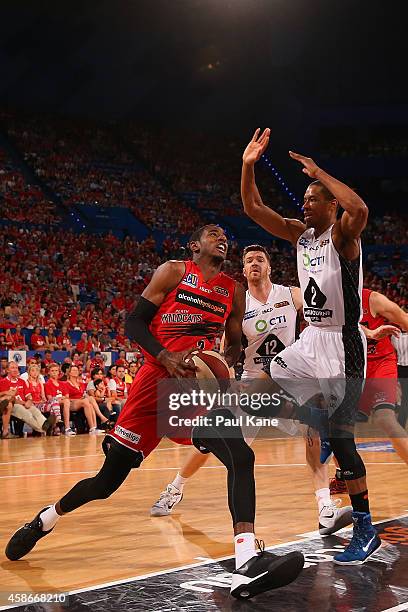 DeAndre Daniels of the Wildcats drives to the basket against Stephen Dennis of United during the round five NBL match between the Perth Wildcats and...