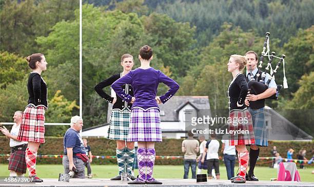 vier highland tänzer bei schwerttanz mit piper - highland games stock-fotos und bilder
