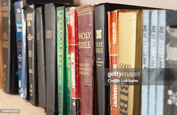 shelf full of bible translations - theology stock pictures, royalty-free photos & images