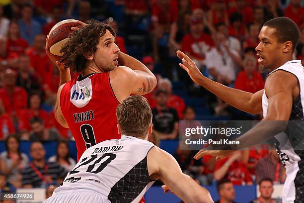 Matt Knight of the Wildcats looks to pass the ball against David Barlow and Stephen Dennis of United during the round five NBL match between the...