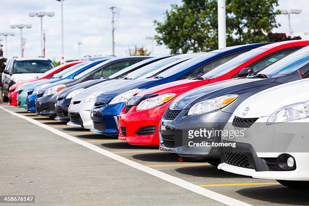 new toyota vehicles in a row at car dealership - toyota motor co stock pictures, royalty-free photos & images