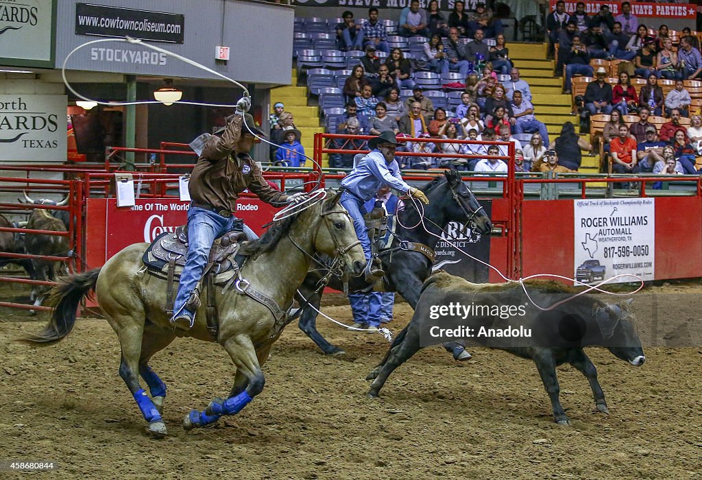 Cowboys try to catch a bull with a rope as they ride horses during a ...