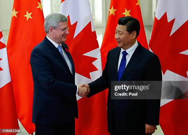 Canadian Prime Minister Stephen Harper shakes hands with Chinese President Xi Jinping during an APAC Bilateral Meeting at the Great Hall of the...