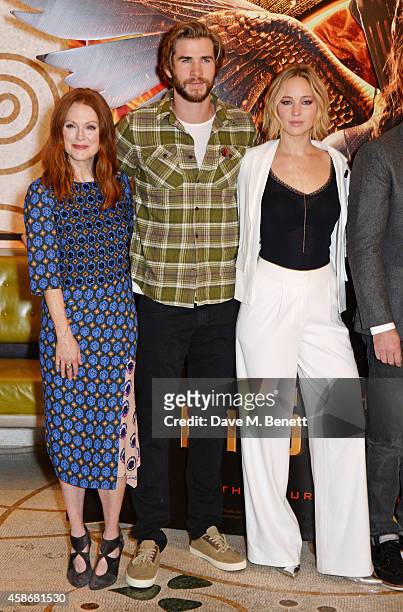 Julianne Moore, Liam Hemsworth and Jennifer Lawrence attend a photocall for "The Hunger Games: Mockingjay Part 1" at the Corinthia Hotel London on...