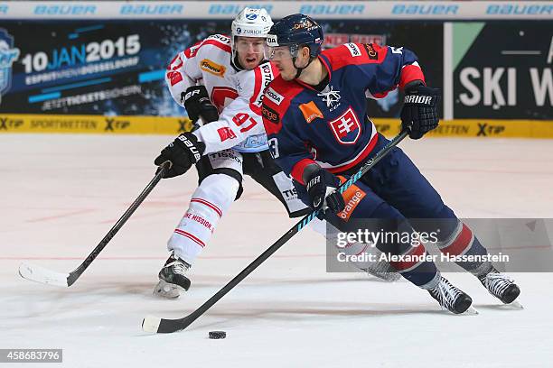 Larri Leeger of Switzerland skates with Martin Bakos of Slovakia during match 5 of the Deutschland Cup 2014 between Slovakia and Switzerland at...