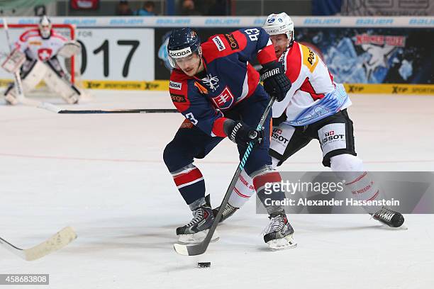 Larri Leeger of Switzerland skates with Martin Bakos of Slovakia during match 5 of the Deutschland Cup 2014 between Slovakia and Switzerland at...
