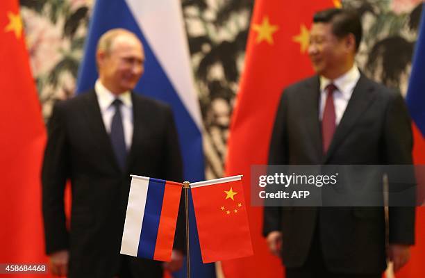 Russian and Chinese national flags are seen on the table with Russian President Vladimir Putin and his Chinese counterpart Xi Jinping in the...