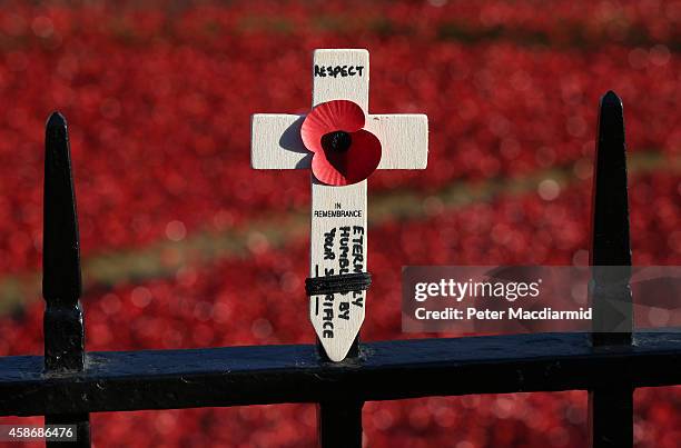 Traditional cross of remembrance is placed on railings surrounding the 'Blood Swept Lands and Seas of Red' installation in the moat of the Tower of...