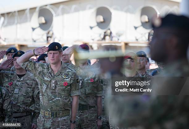 Prince Harry salutes as the Last Post is played as he joins British troops and service personal remaining in Afghanistan and also International...