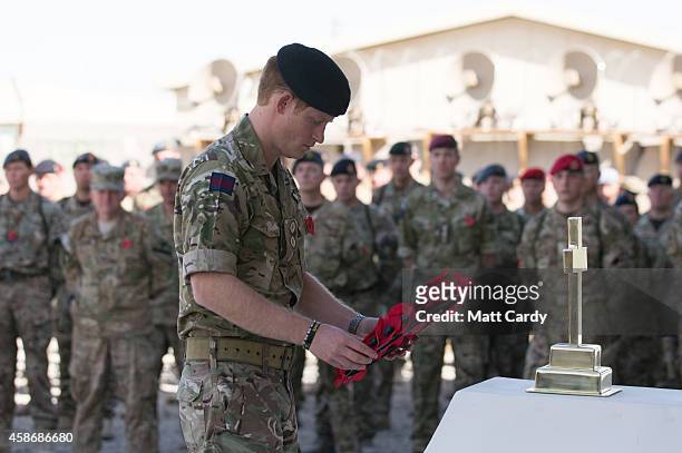 Prince Harry lays a poppy wreath as he joins British troops and service personal remaining in Afghanistan and International Security Assistance Force...