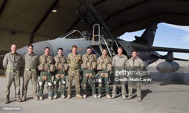 Prince Harry climbs to meet pilots and ground crew of a RAF Tornado following a Remembrance Sunday service at Kandahar Airfield November 9, 2014 in...