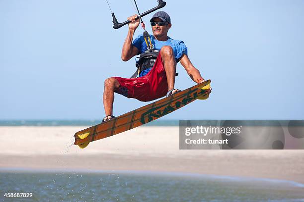 young man kite surfing in a lagoon of jericoacoara, brazil - kite lagoon stock pictures, royalty-free photos & images