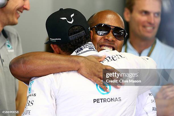 Lewis Hamilton of Great Britain and Mercedes GP hugs his father Anthony in the garage before the Brazilian Formula One Grand Prix at Autodromo Jose...