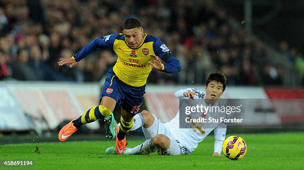 Arsenal player Alex Oxlade-Chamberlin is fouled by Ki Sung-Yueng during the Barclays Premier League match between Swansea City and Arsenal at Liberty...