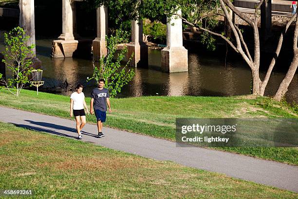 couple walking in the park - hermann park stock pictures, royalty-free photos & images