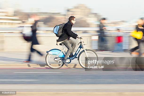 boy using the barclays bicycle sharing scheme - barclays cycle hire stock pictures, royalty-free photos & images