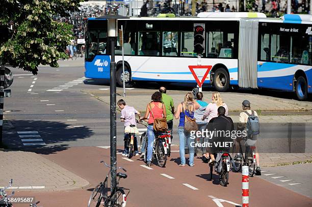 cyclists waiting at red traffic light in utrecht - utrecht stock pictures, royalty-free photos & images