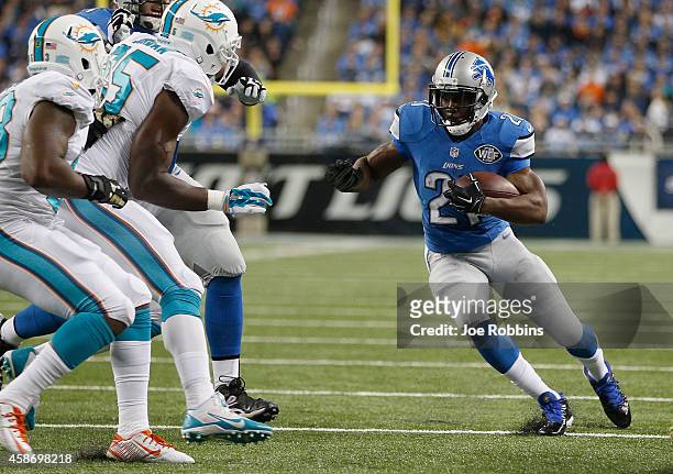 Reggie Bush of the Detroit Lions looks to avoid the tackle by Jelani Jenkins and Dion Jordan of the Miami Dolphins in the first quarter at Ford Field...