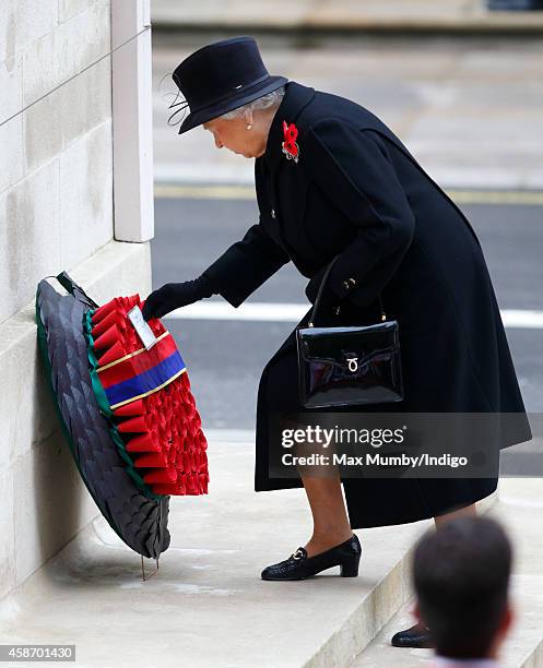 Queen Elizabeth II lays a wreath as she attends the annual Remembrance Sunday Service at the Cenotaph on Whitehall on November 9, 2014 in London,...