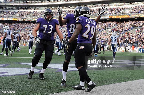 Running back Justin Forsett of the Baltimore Ravens is congratulated by teammates Torrey Smith and Marshal Yanda after scoring a third quarter...
