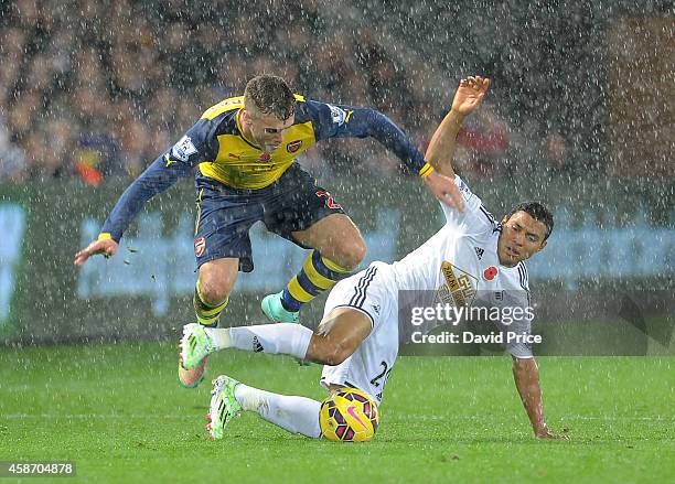 Calum Chambers of Arsenal skips over Jefferson Montero of Swansea during the match between Swansea and Arsenal in the Barclays Premier League at...