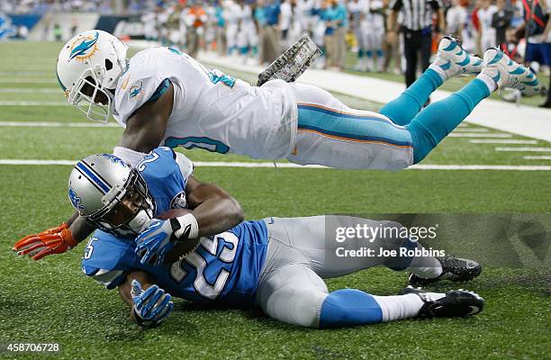 Theo Riddick of the Detroit Lions catches a fourth quarter touch down pass in front of Reshad Jones of the Miami Dolphins at Ford Field on November...